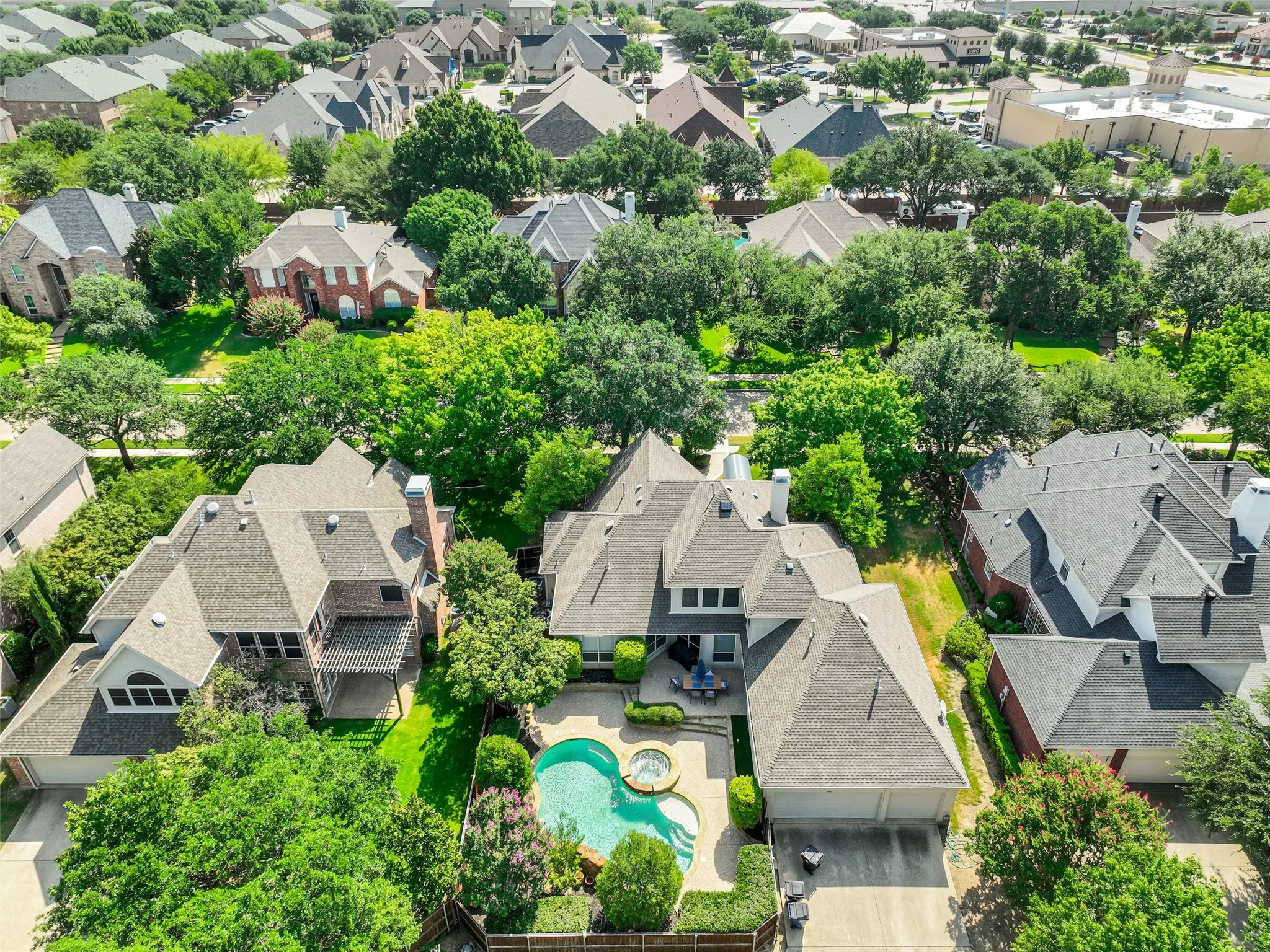 Aerial perspective showcasing a residential property with a private backyard oasis