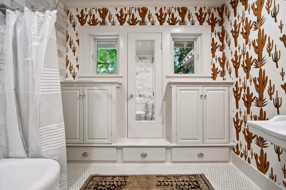 Bathroom featuring white shaker-style cabinetry, integrated storage drawers, and dual windows