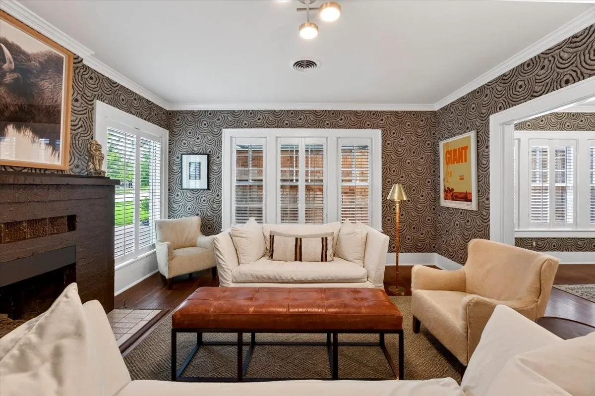 Living area featuring patterned wallpaper and wood-finish flooring
