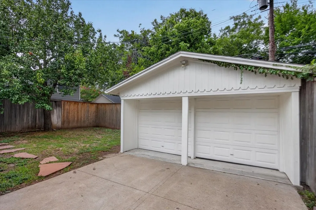 Detached two-car garage with white panel doors and a gabled roofline