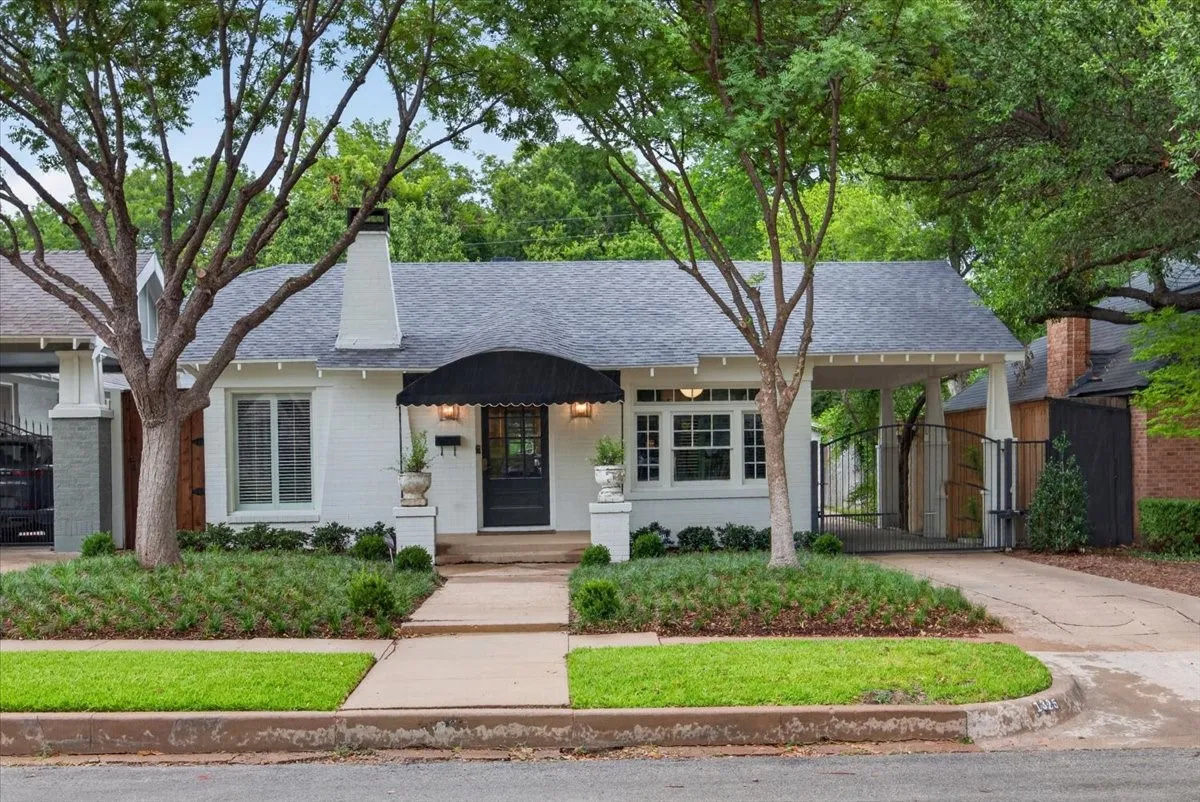 White painted brick exterior with a dark shingle roof and a covered entry