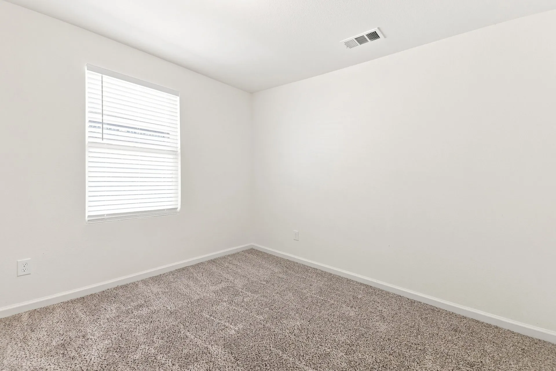 Neutral-toned wall-to-wall carpeting and crisp white walls
