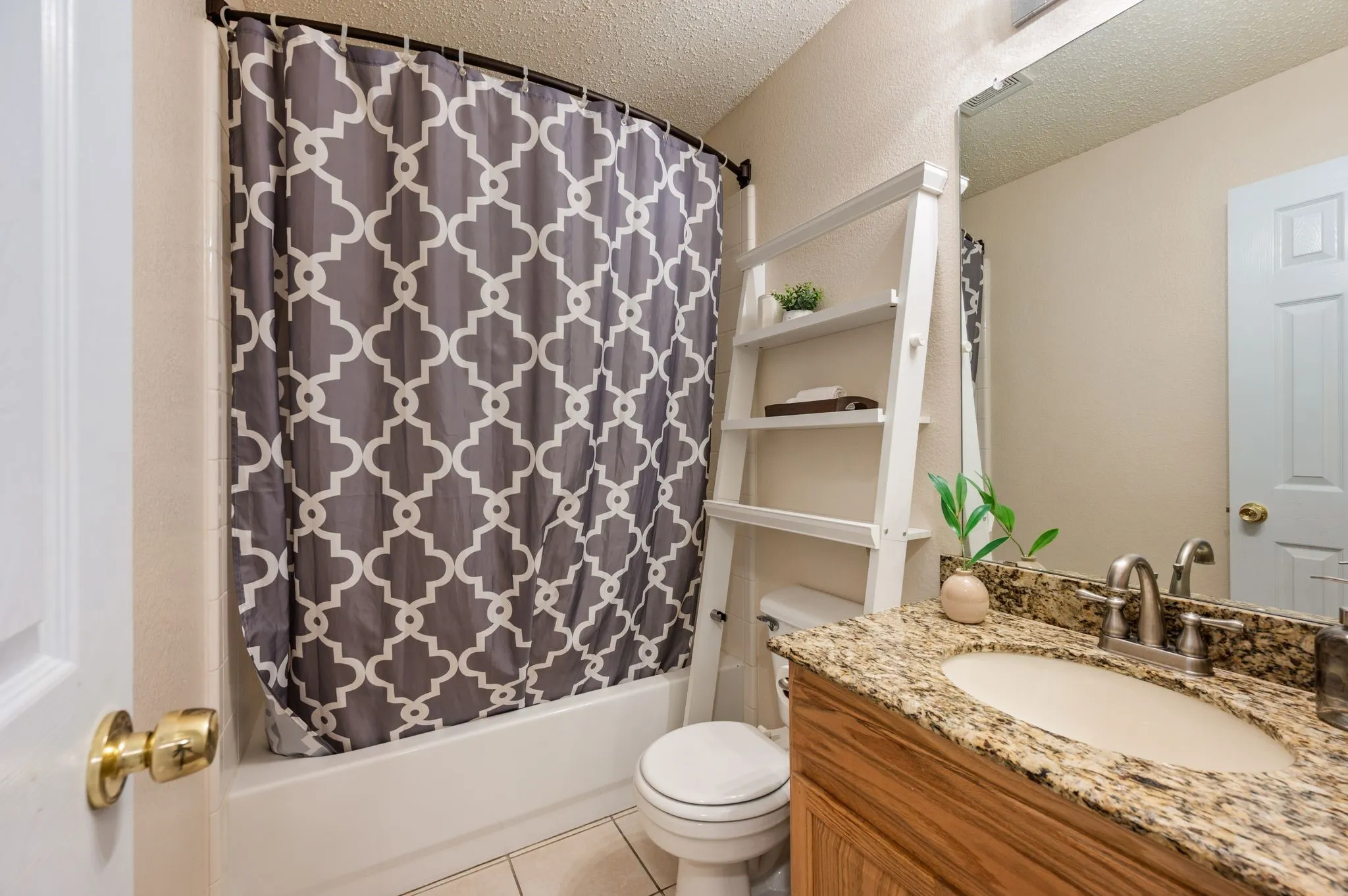 Bathroom vanity with granite-style countertop, undermount sink, and brushed nickel faucet