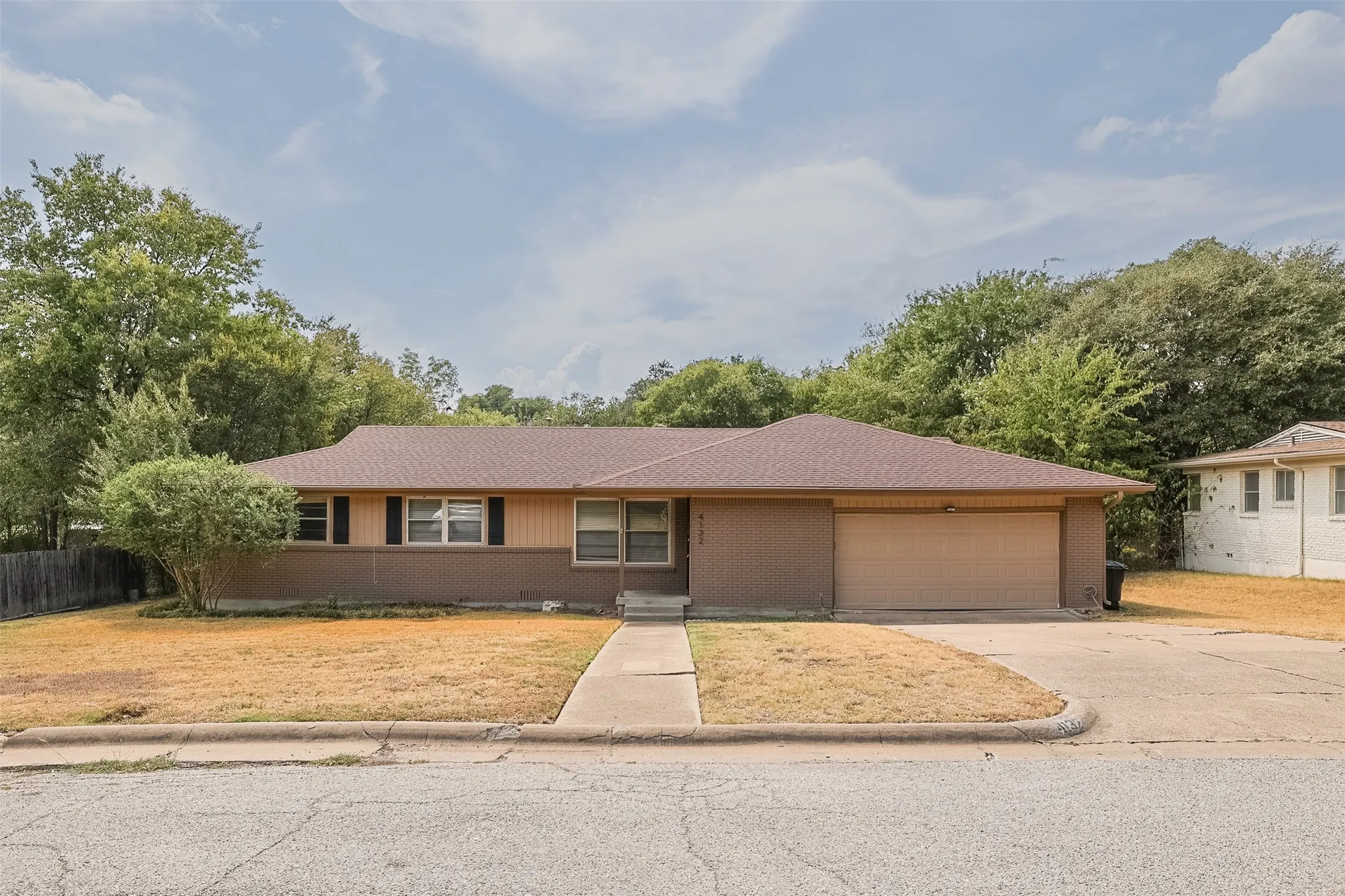 Single-story residence featuring a brown shingle roof, attached garage, and a concrete driveway