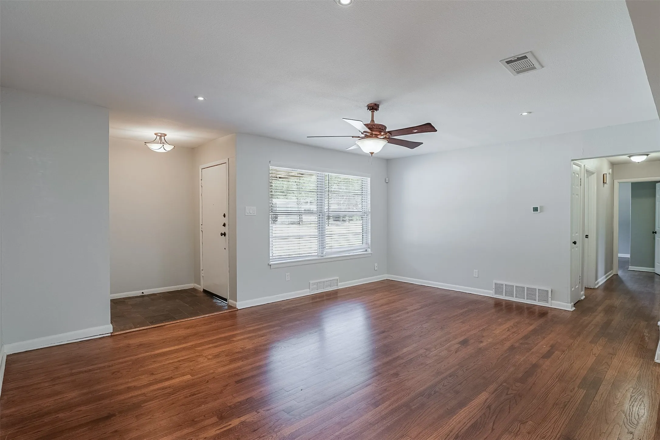 Wood-finish flooring, recessed lighting, and a ceiling fan with integrated lighting