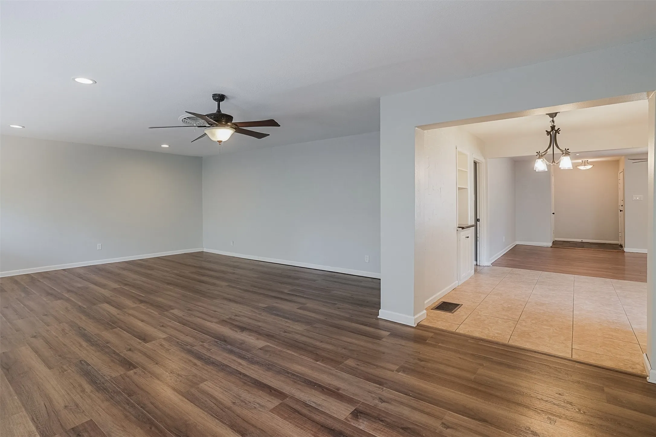 Expansive room featuring wood-finish flooring, recessed lighting, and a ceiling fan