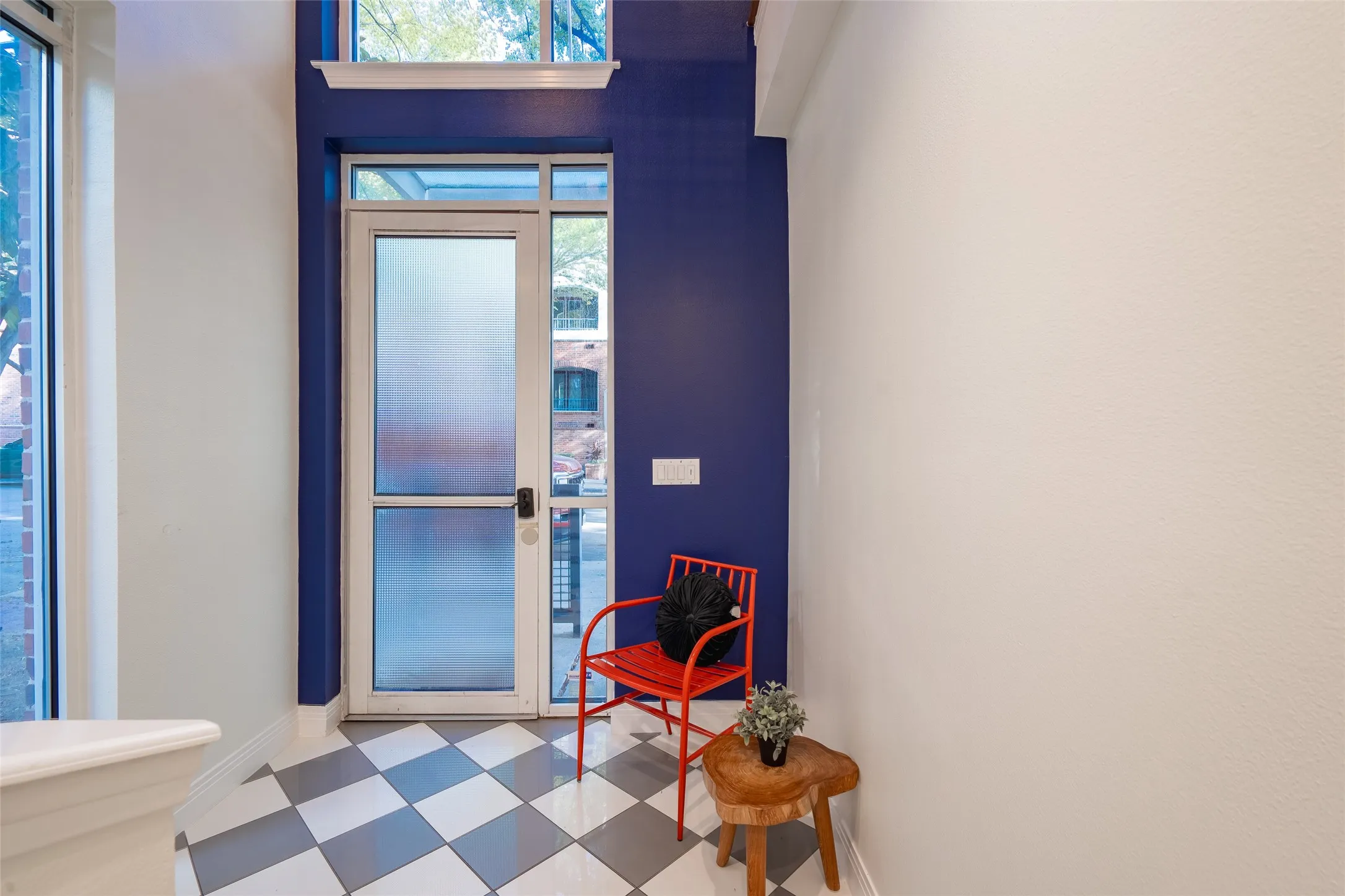 Entryway featuring checkered tile flooring, a frosted glass door, and a transom window