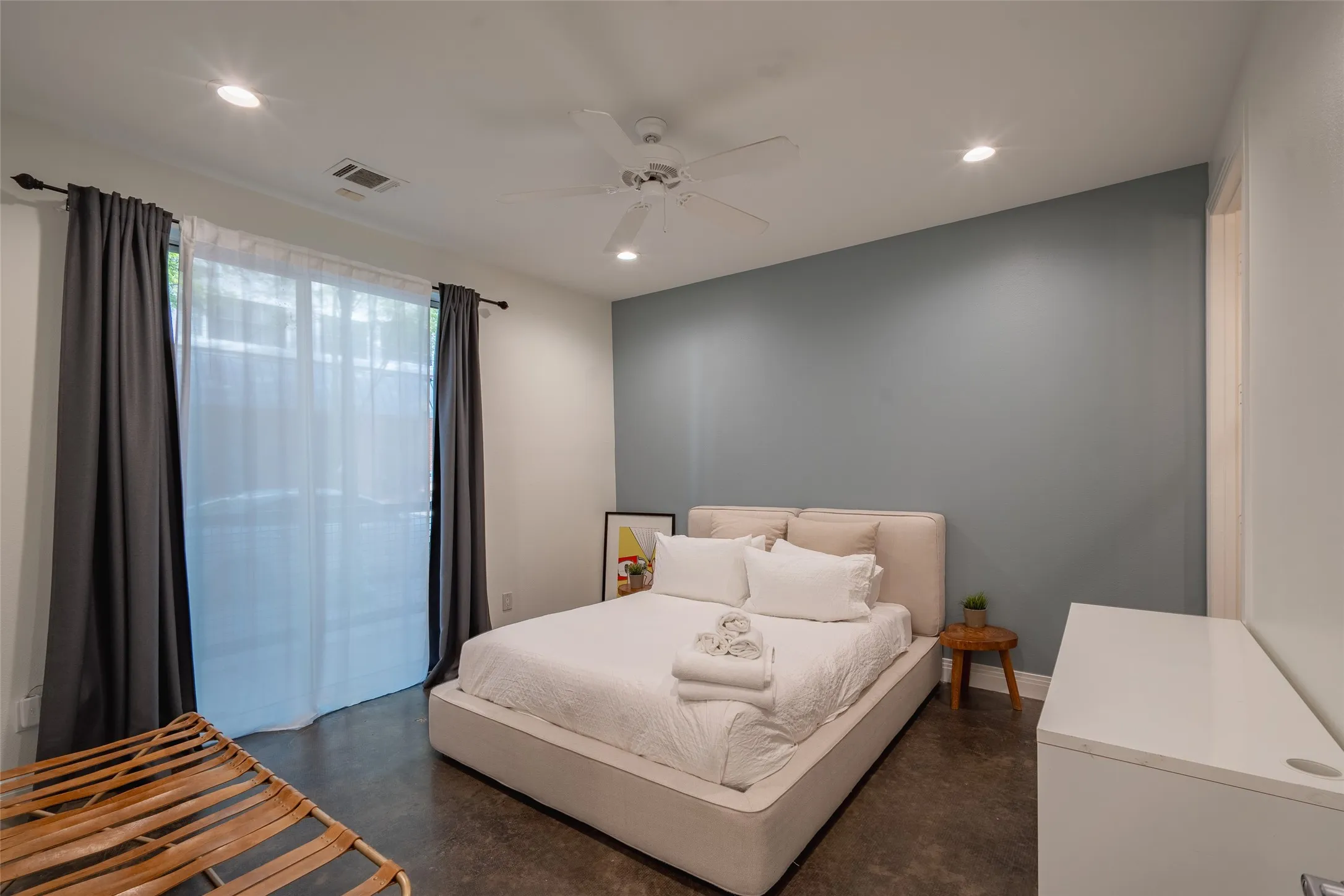 Bedroom featuring a light blue accent wall, recessed lighting, and a ceiling fan