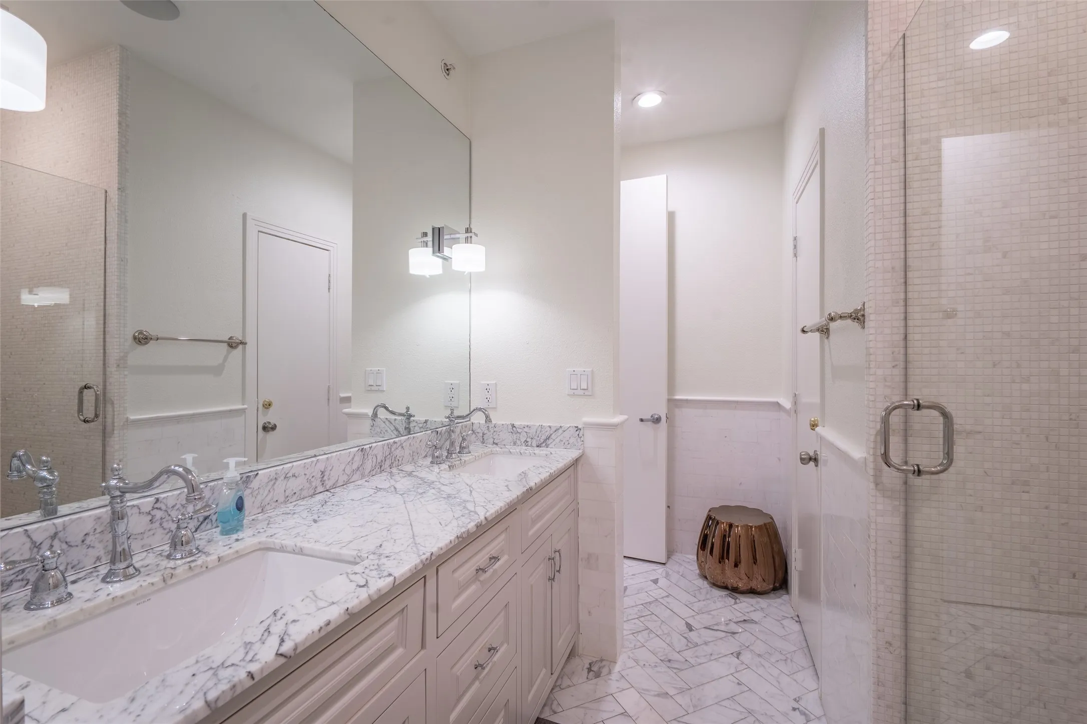Double vanity with stone countertop, dual undermount sinks, and polished chrome fixtures