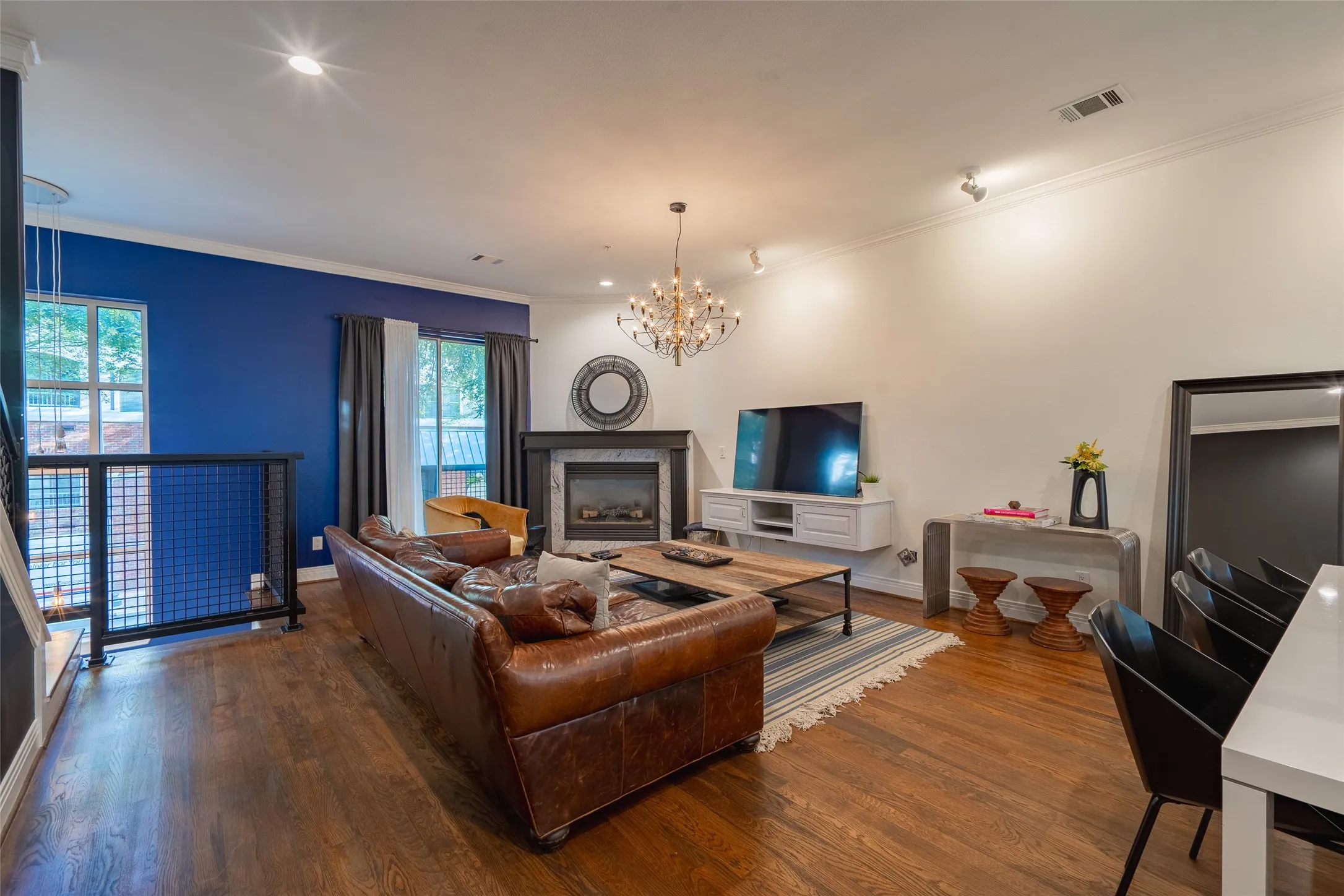 Spacious living area featuring wood-finish flooring and crown molding