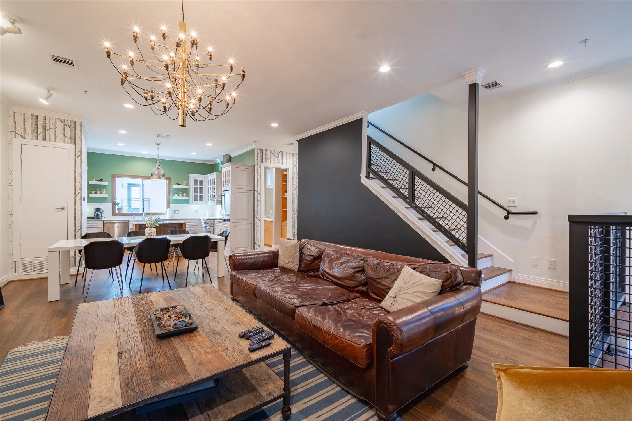 Open-concept living space featuring wood-finish flooring and a prominent chandelier