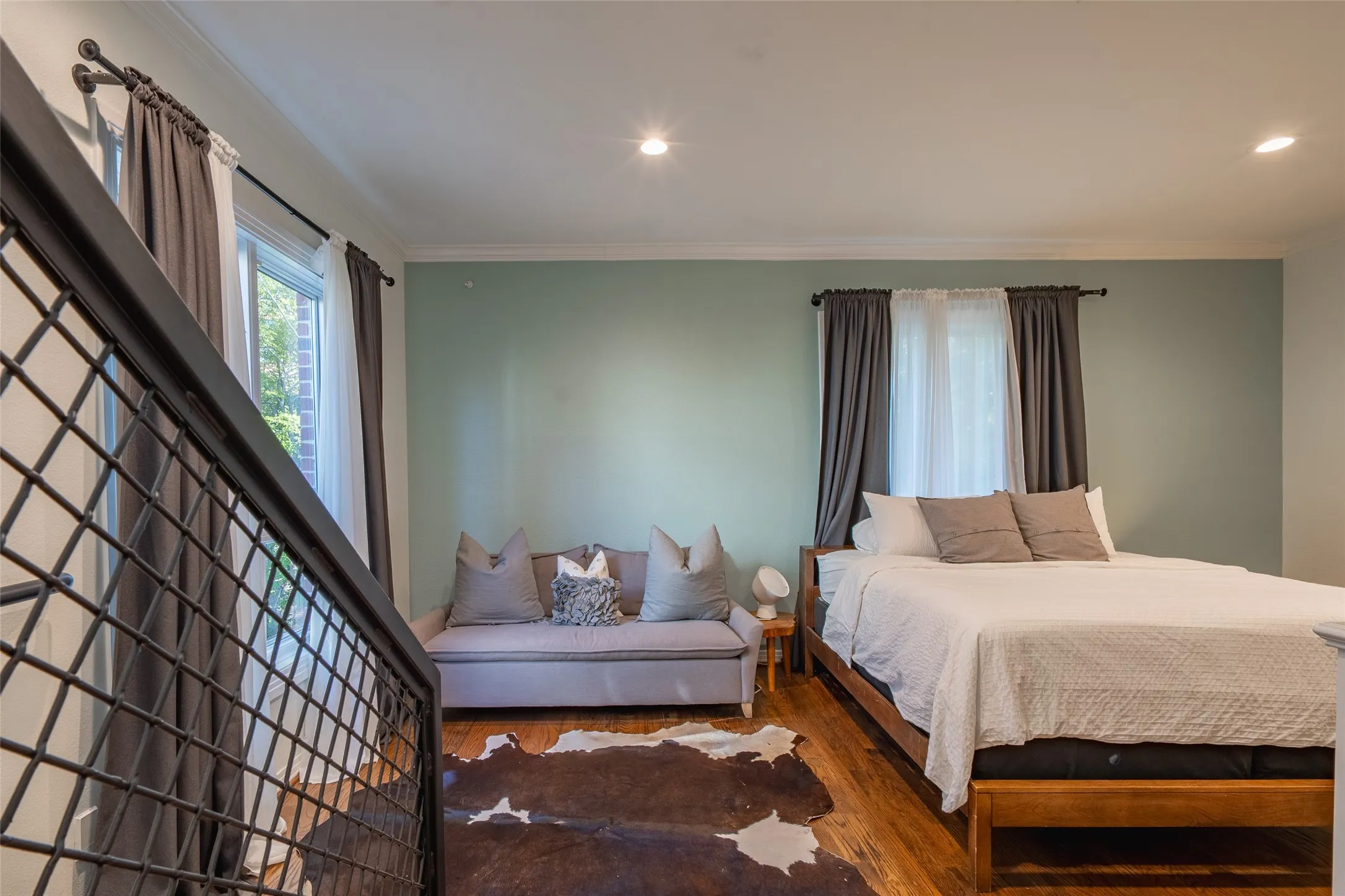 Hardwood-style flooring throughout this space with a metal grid railing