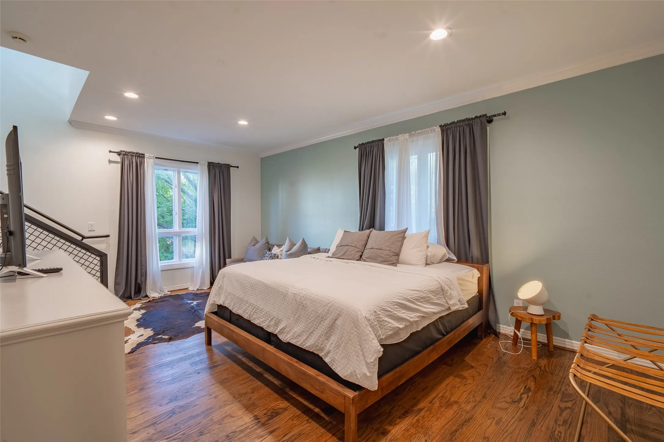 Spacious room featuring wood-finish flooring, recessed ceiling lighting, and a window with natural light