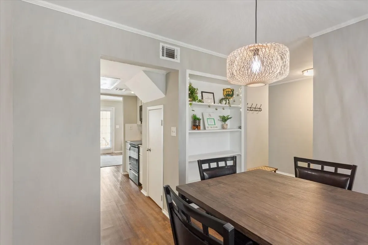 Dining area with built-in shelving and seamless flow into the kitchen and living room.