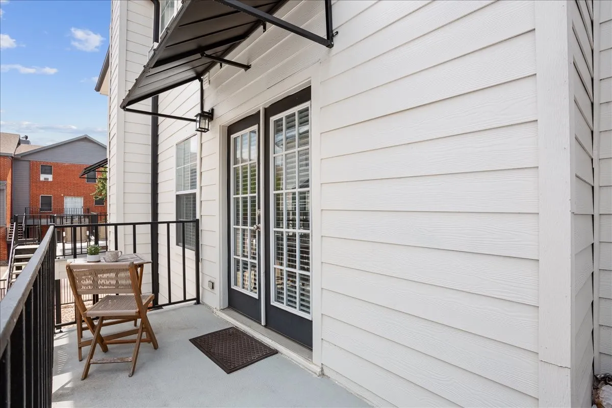 French doors and a modern black metal awning create a stylish transition to the home's outdoor living space.