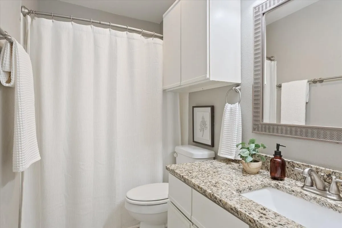 Updated secondary bathroom with granite countertops and modern finishes.