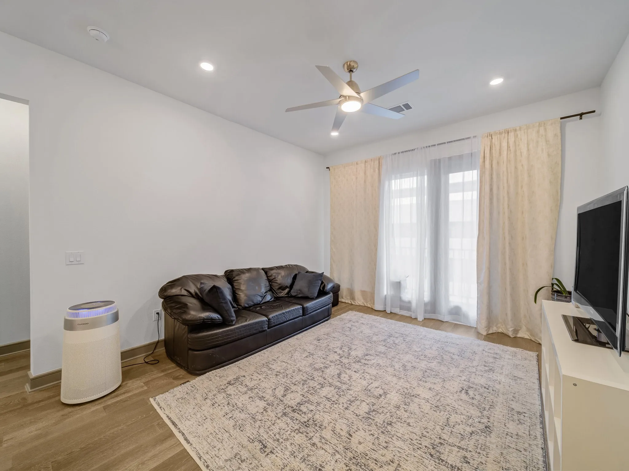 Living area featuring wood-finish flooring, recessed lighting, and a ceiling fan