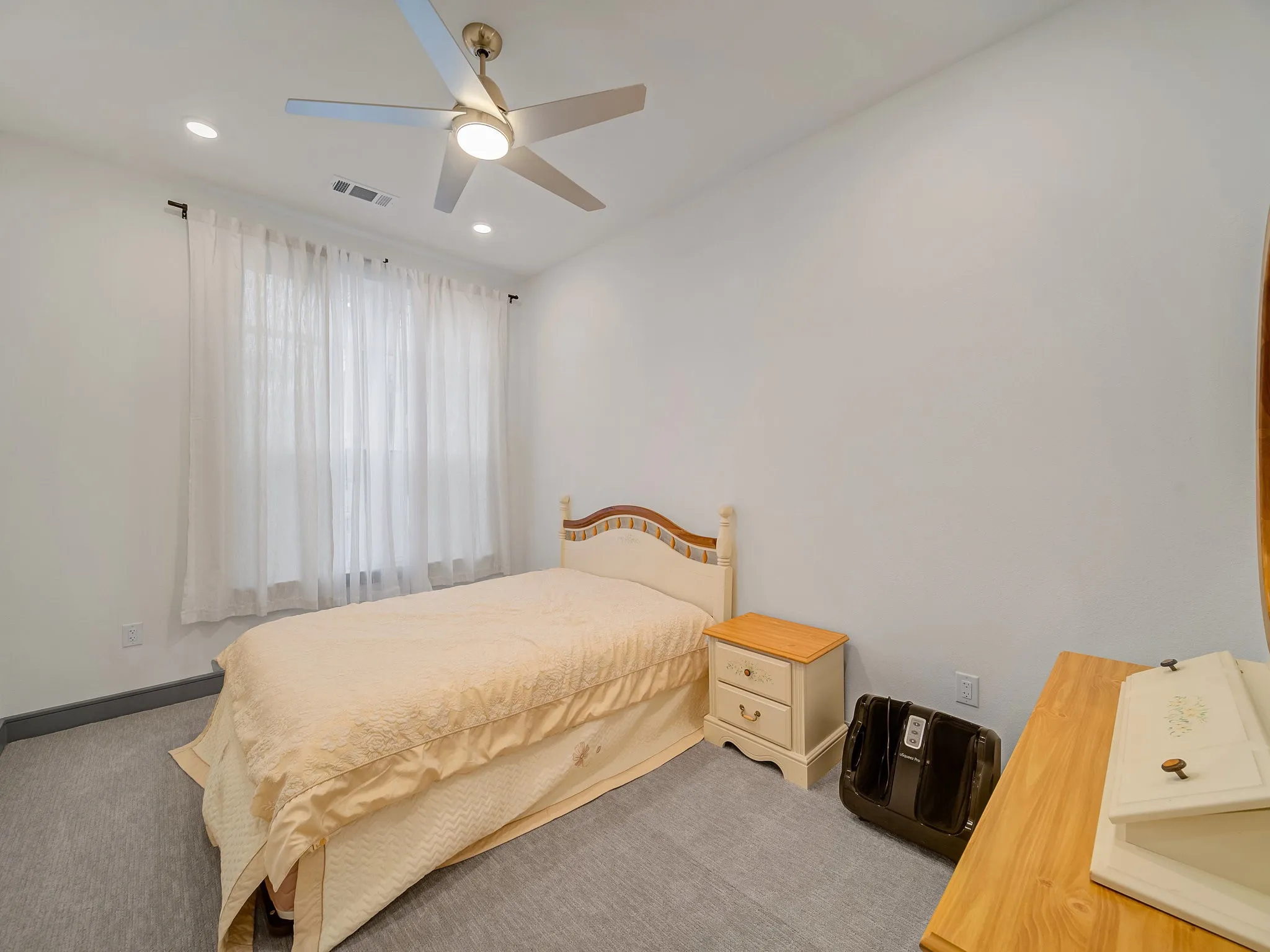 Room featuring light gray carpet, white walls, recessed lighting, and a ceiling fan with integrated light