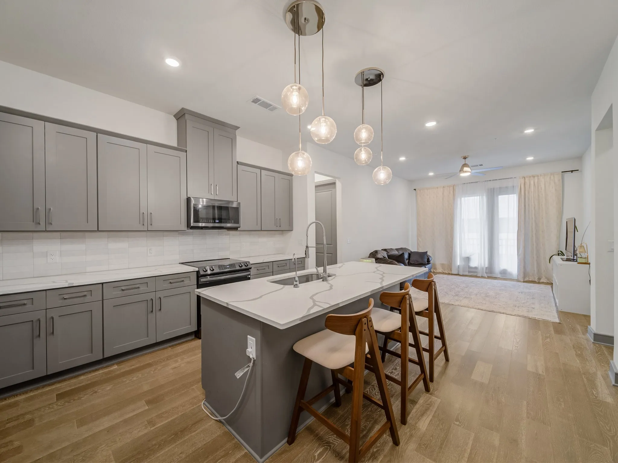 Kitchen island with seating for three, quartz countertop, and pendant lighting