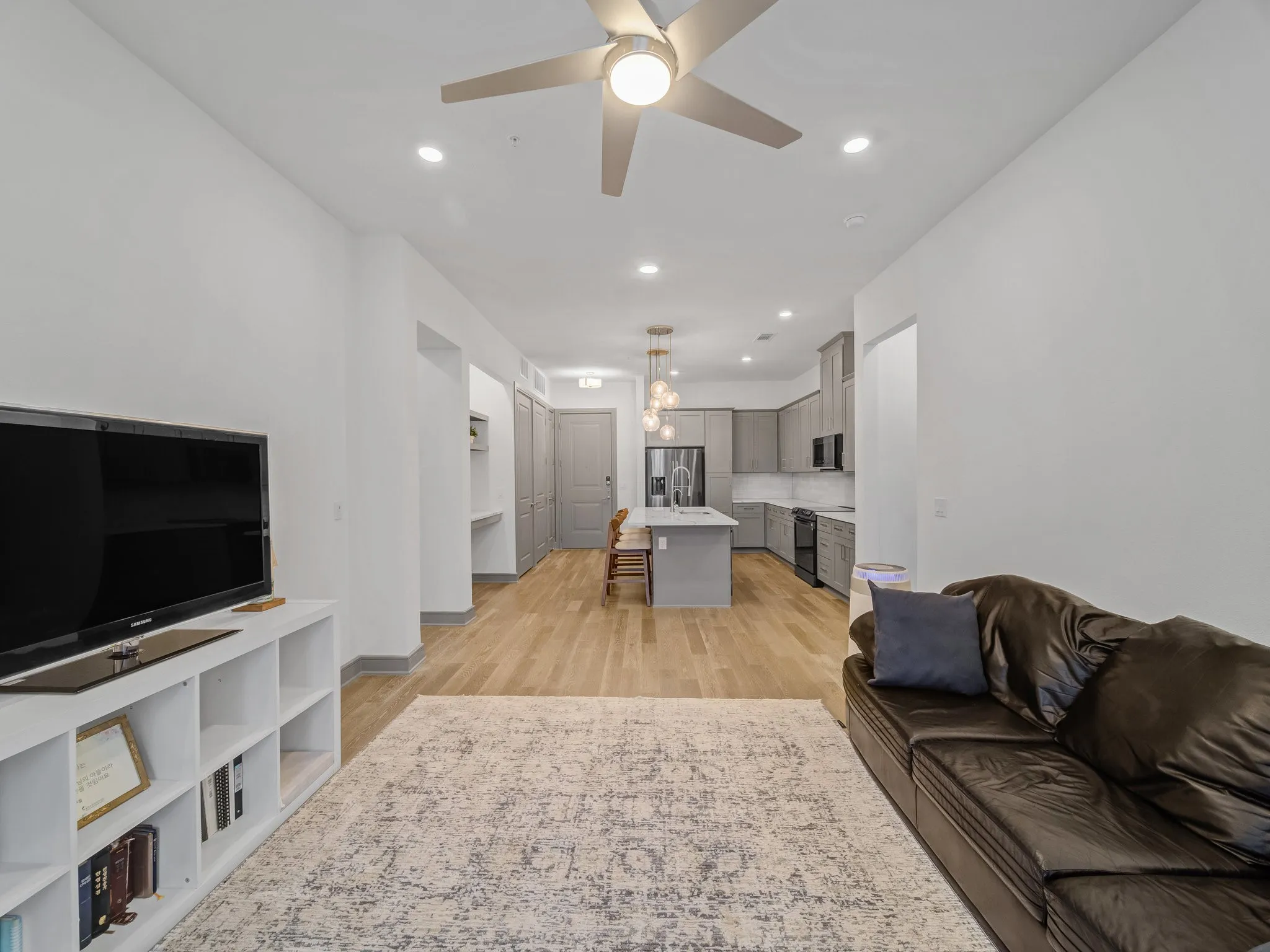 Open-concept living space featuring wood-finish flooring, recessed lighting, and a modern ceiling fan