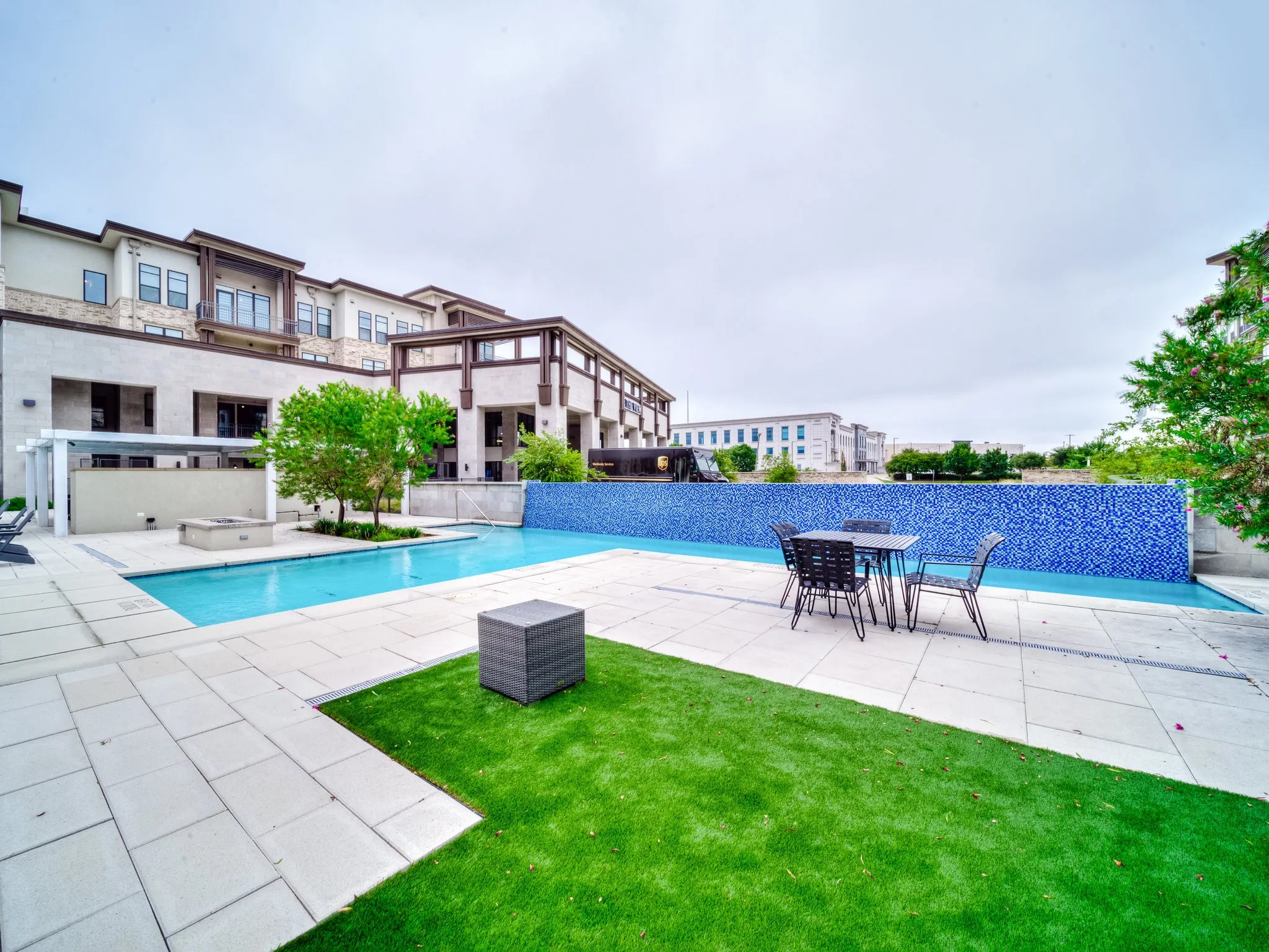 Resort-style pool with a blue mosaic tile water feature and a surrounding paver patio