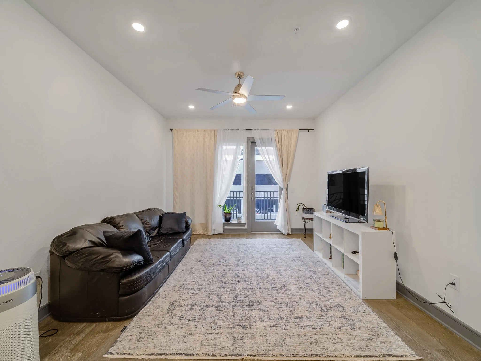 Bright living area featuring wood-finish flooring, recessed lighting, and a ceiling fan