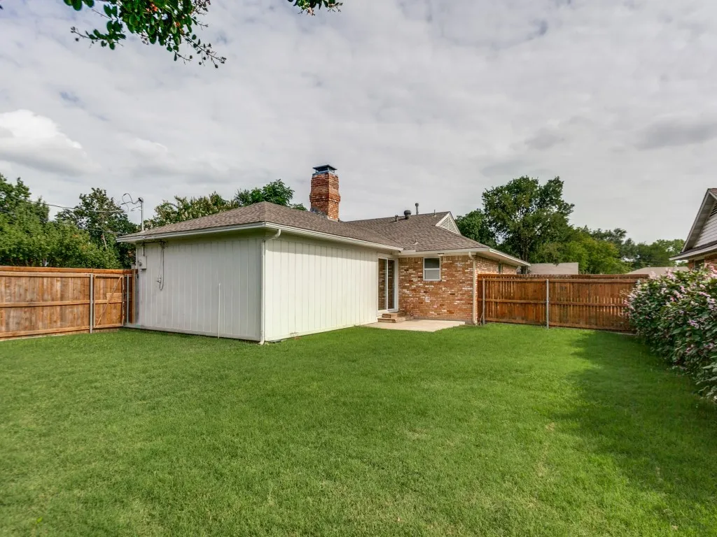 Expansive green lawn with a wood privacy fence