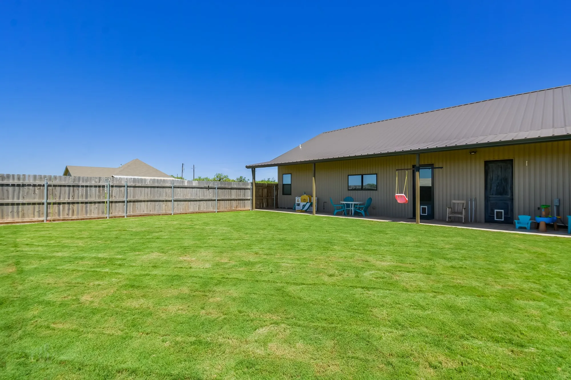 Expansive green lawn with full wood privacy fencing