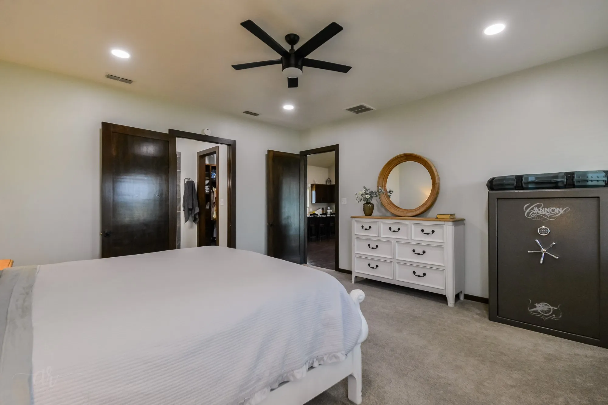 Neutral wall finishes with recessed lighting and a ceiling fan