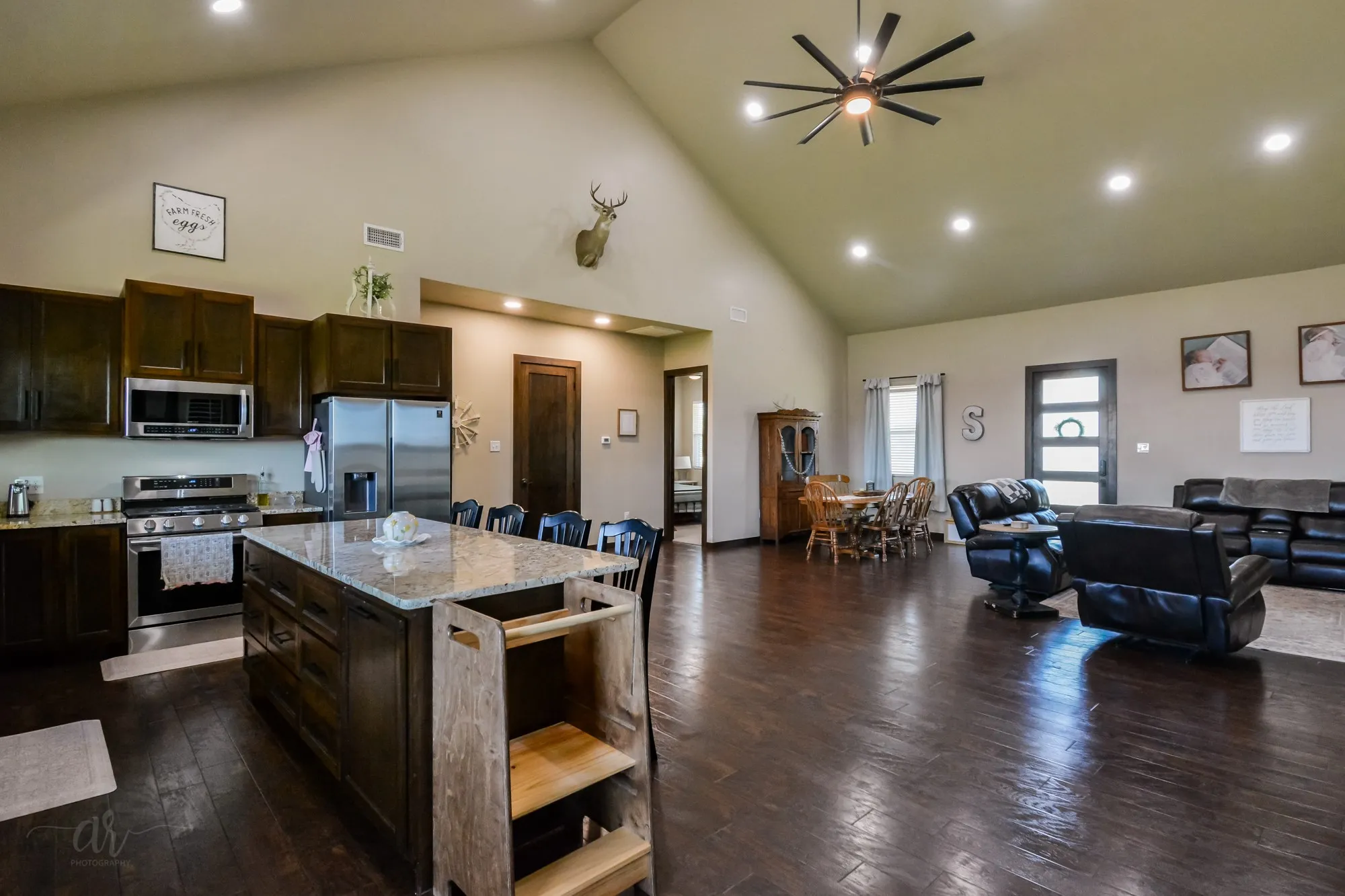 Open concept living area featuring dark wood-finish flooring, vaulted ceilings, and recessed lighting