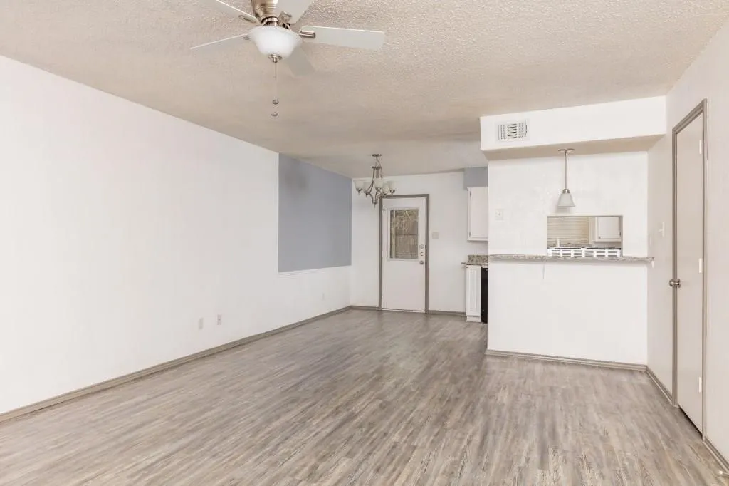 Spacious open-concept living area featuring wood-finish flooring, a ceiling fan, and recessed lighting