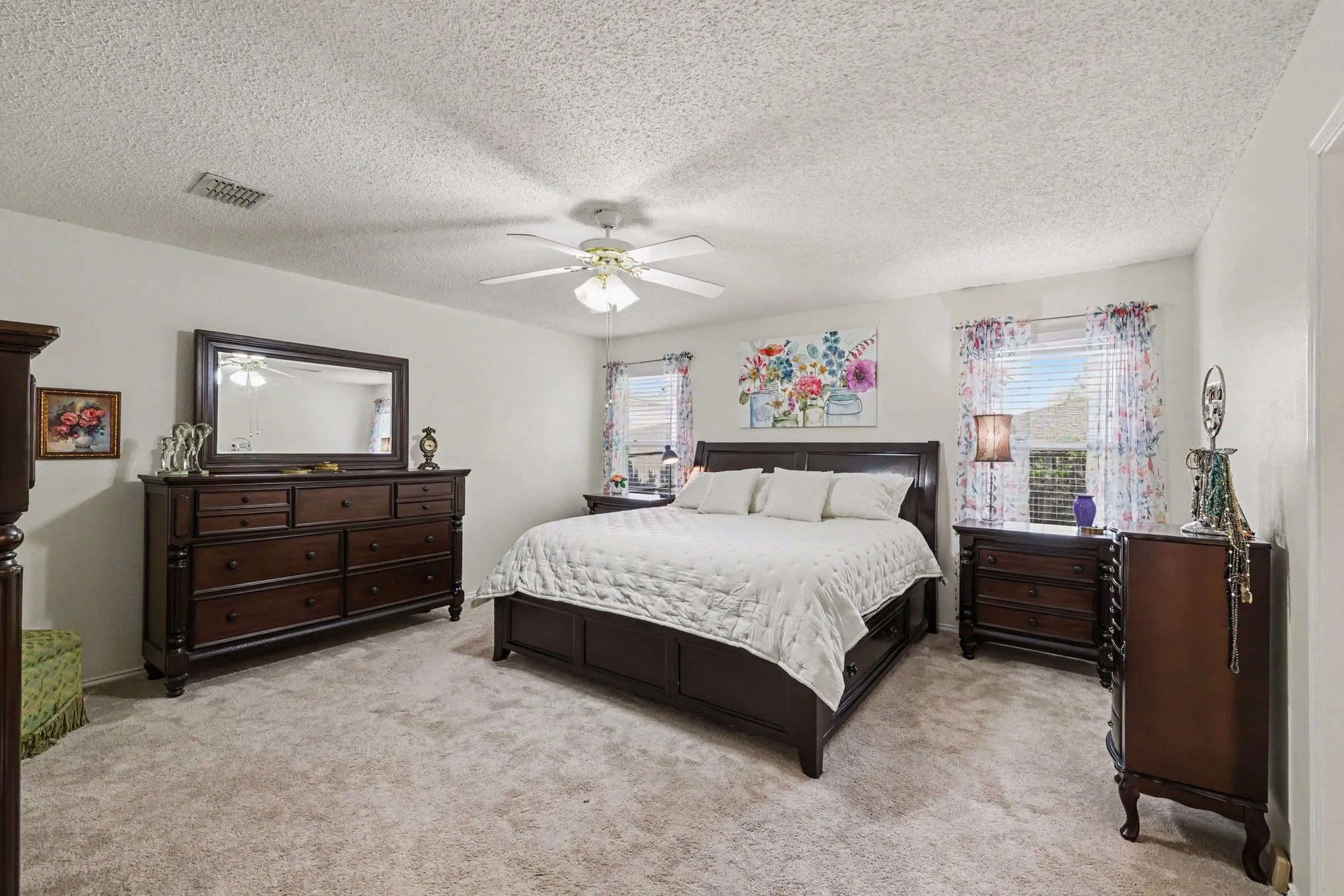 Primary bedroom has room for siting area, ceiling fan