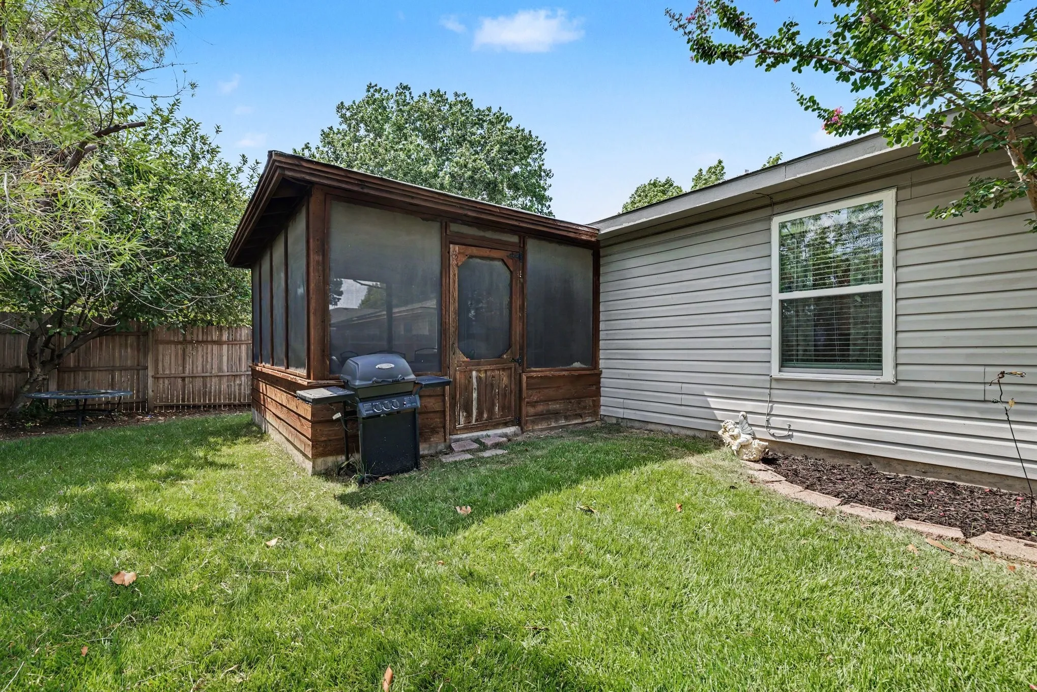 Grassy backyard and screened in porch