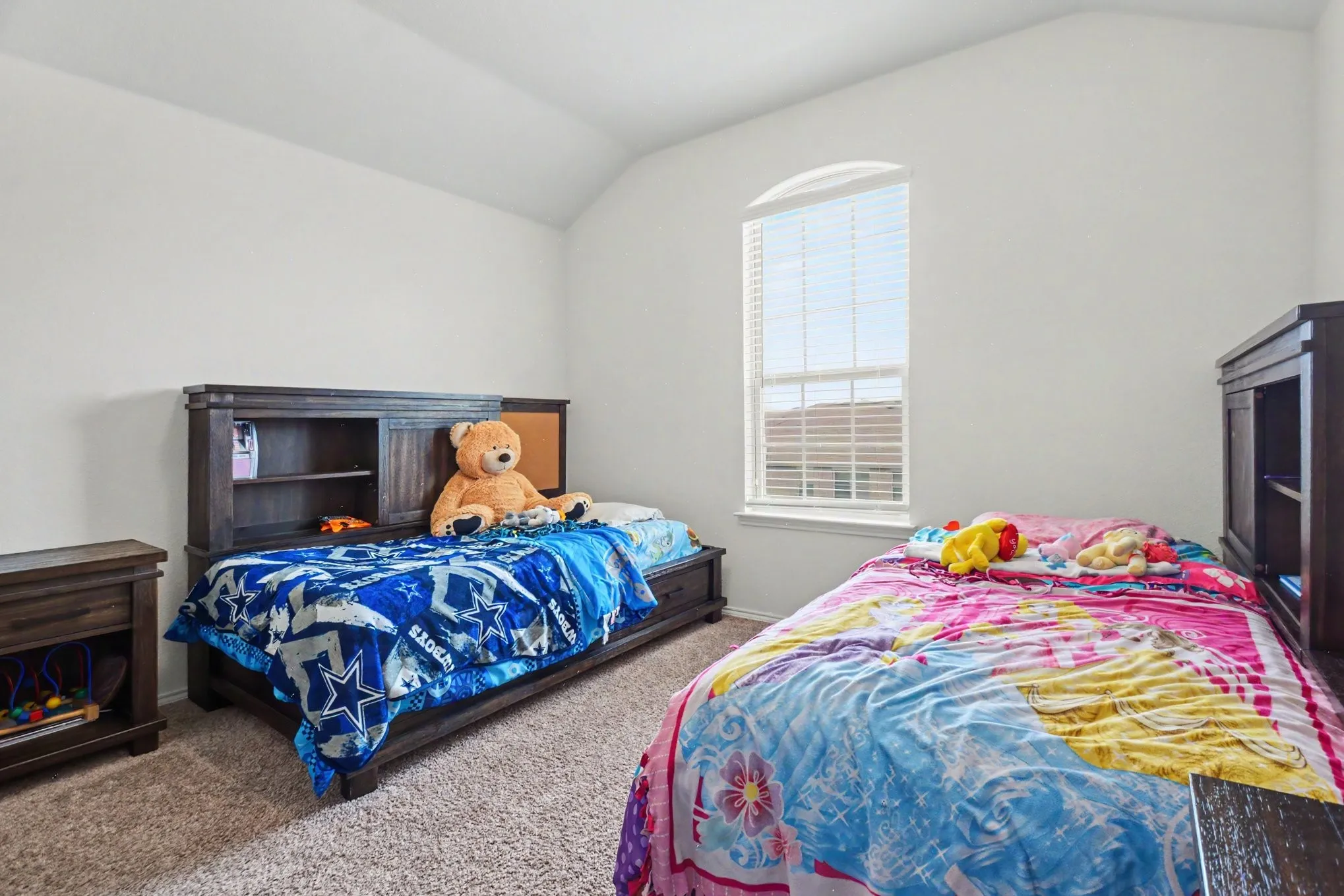 Room featuring a vaulted ceiling, neutral wall paint, and carpet flooring