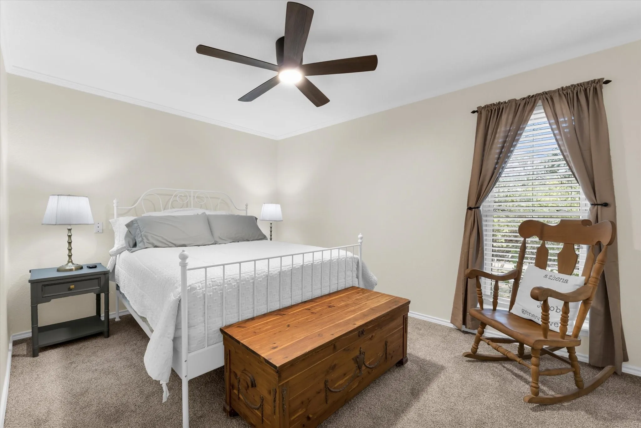Carpeted room with a ceiling fan, crown molding, and a window featuring blinds and drapes