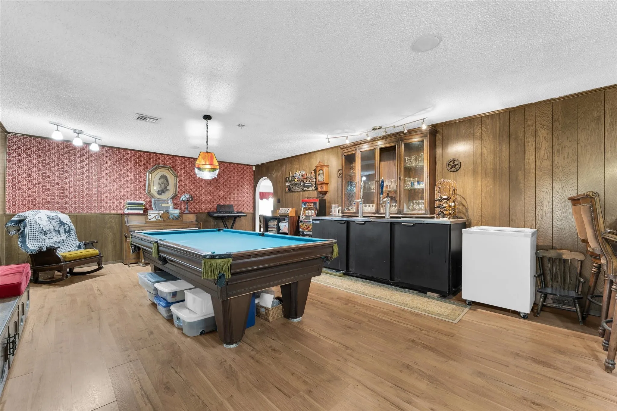 Spacious recreation room featuring wood-finish flooring and a built-in wet bar