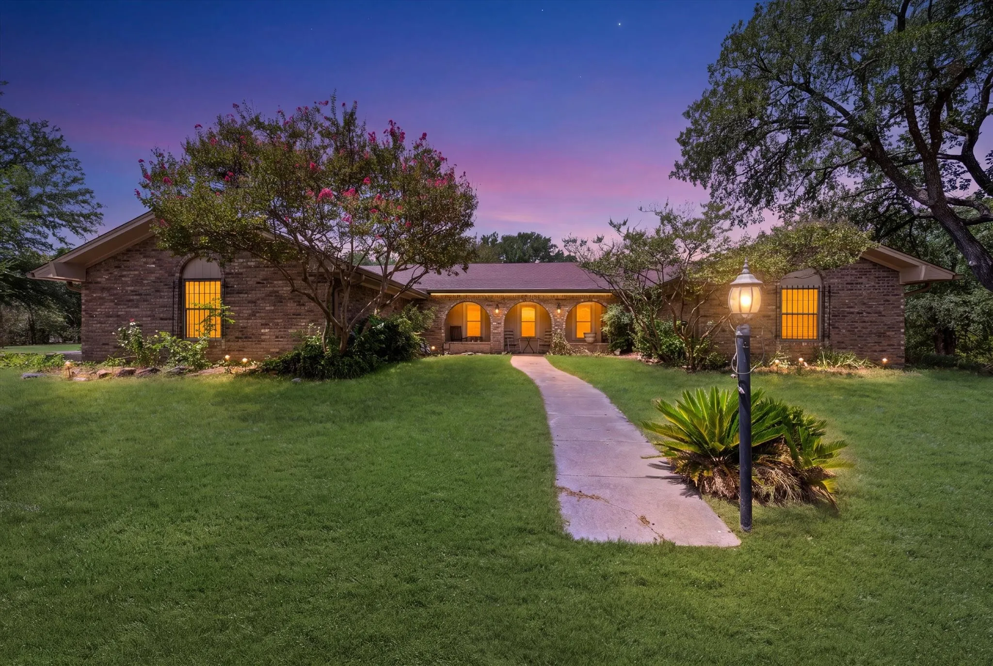 Brick exterior residence featuring arched entryways and windows