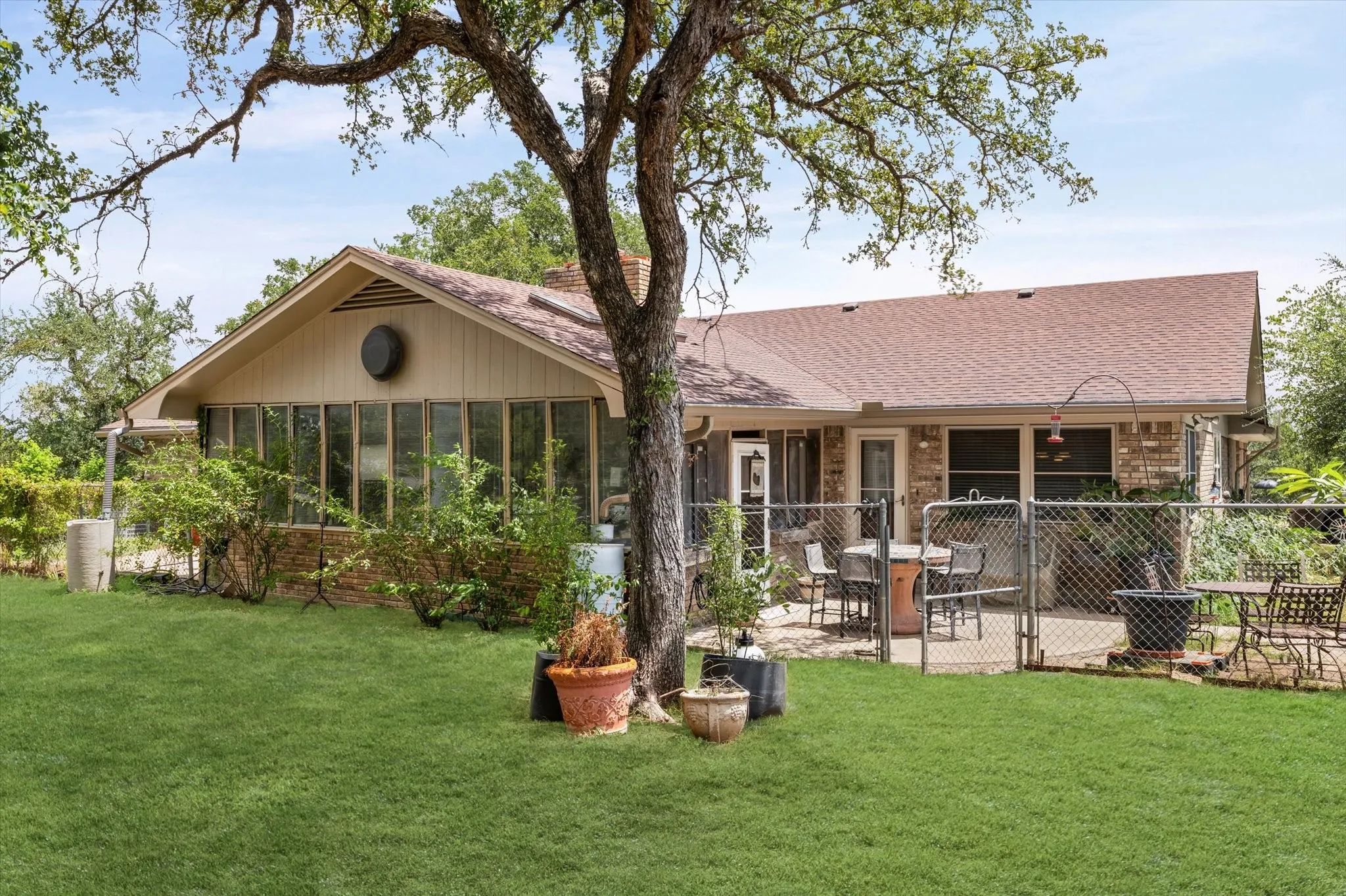 Expansive backyard featuring a manicured lawn and mature trees