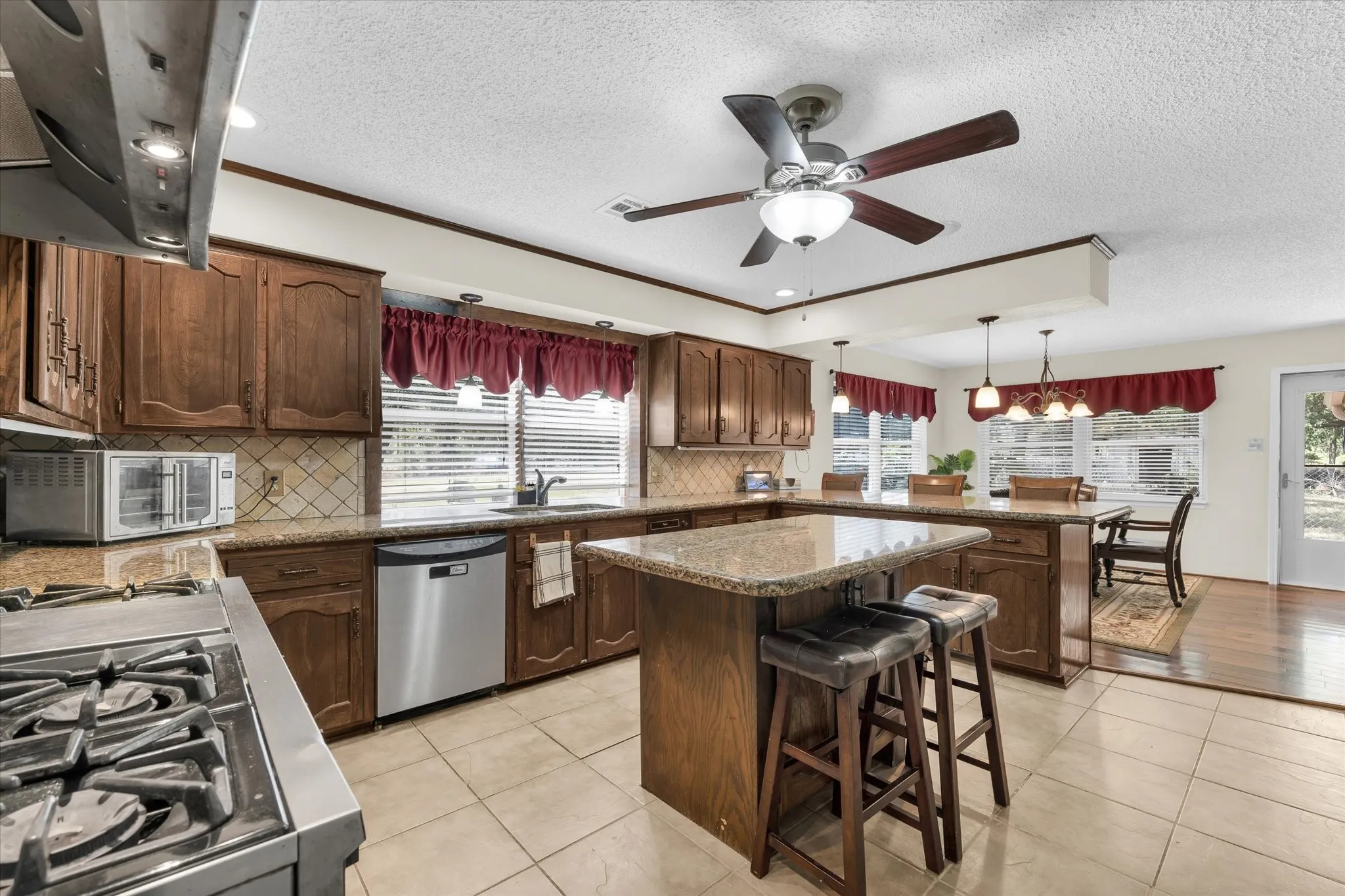 Kitchen featuring wood cabinetry, granite countertops, and tile flooring