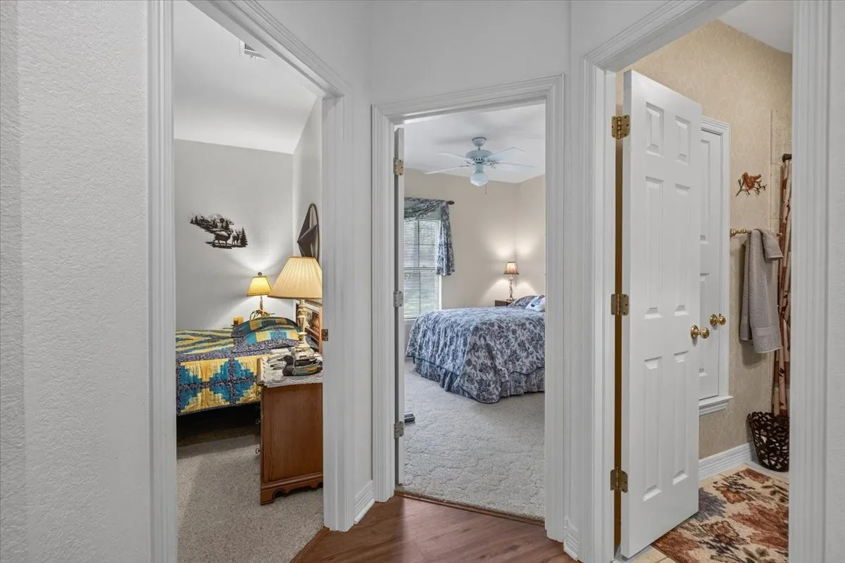Hallway featuring wood-finish flooring and white paneled doors