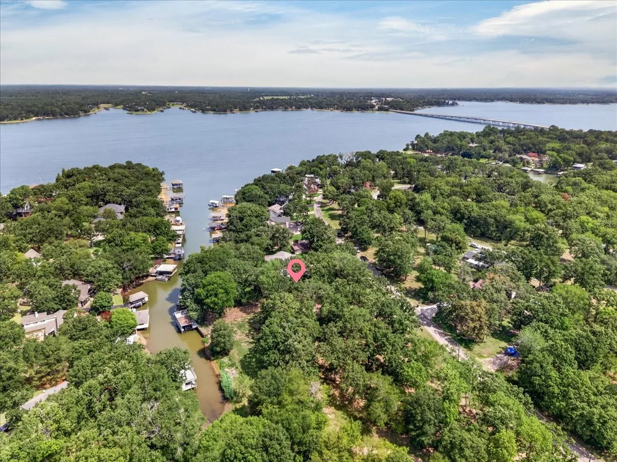 Waterfront property featuring private boat dock, mature tree coverage, and a serene channel canal setting