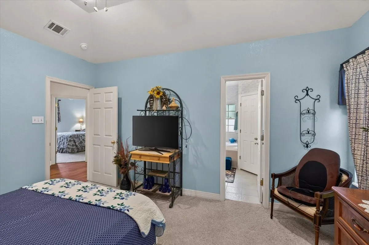 Bedroom with light blue walls and neutral carpet flooring