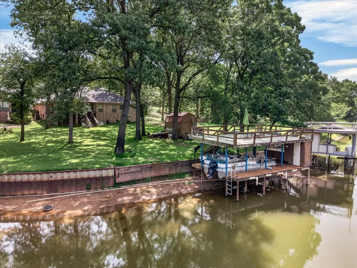 Concrete retaining wall, Private boat double deck boathouse featuring a covered pontoon slip, upper deck, and additional covered slip, with storage closet.  Water levels fluctuate - the lake will fill up - it always does.  Even on low lake level seasons - we all manage to have fun. These periodic seasons give owners time to maintain their boathouses and walls along with clean up shorelines and repair irrigation pvc lines which water your yard.