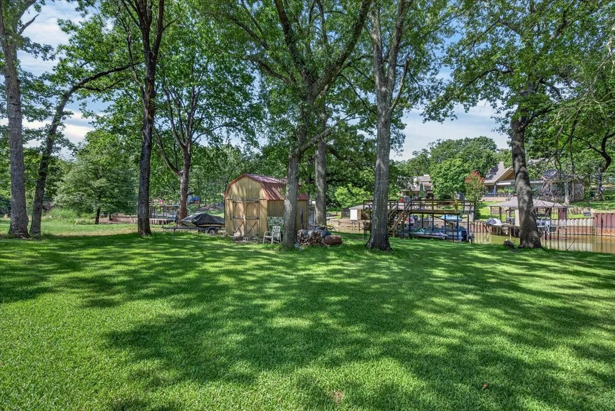 Expansive green lawn with mature trees providing dappled shade. Get the yard games set up.  What a nice size yard with plenty of shaded space for entertaining friends and family.