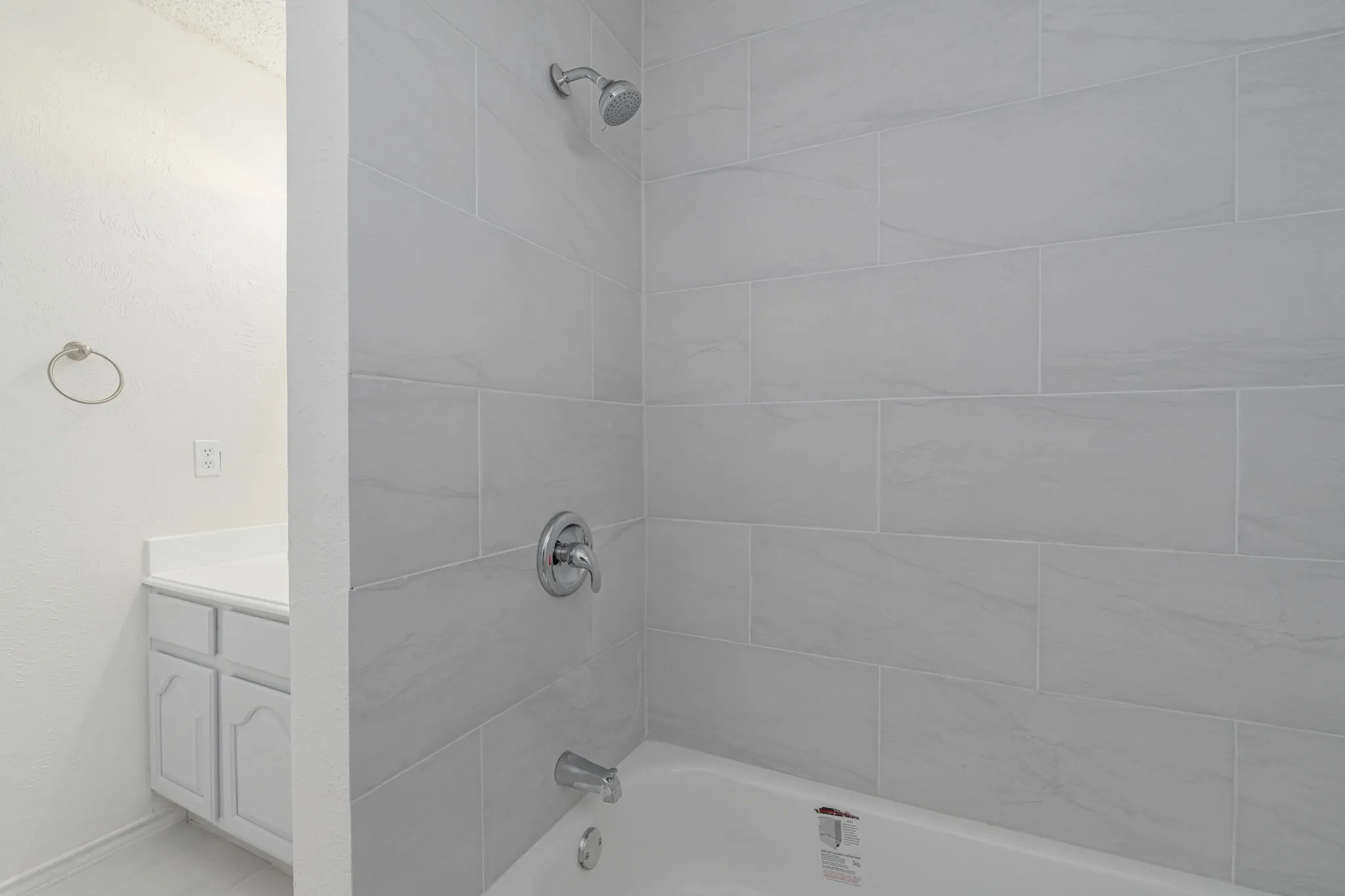 Freshly updated tub and shower feature stylish large-format tile for a clean, timeless look that's ready to enjoy.