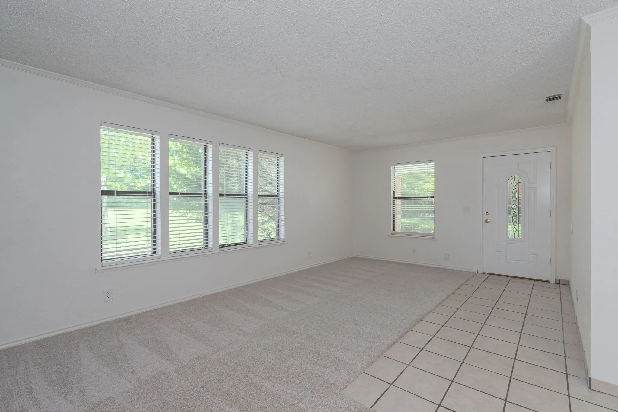 Large windows fill the spacious living area with natural light while showcasing peaceful outdoor views.