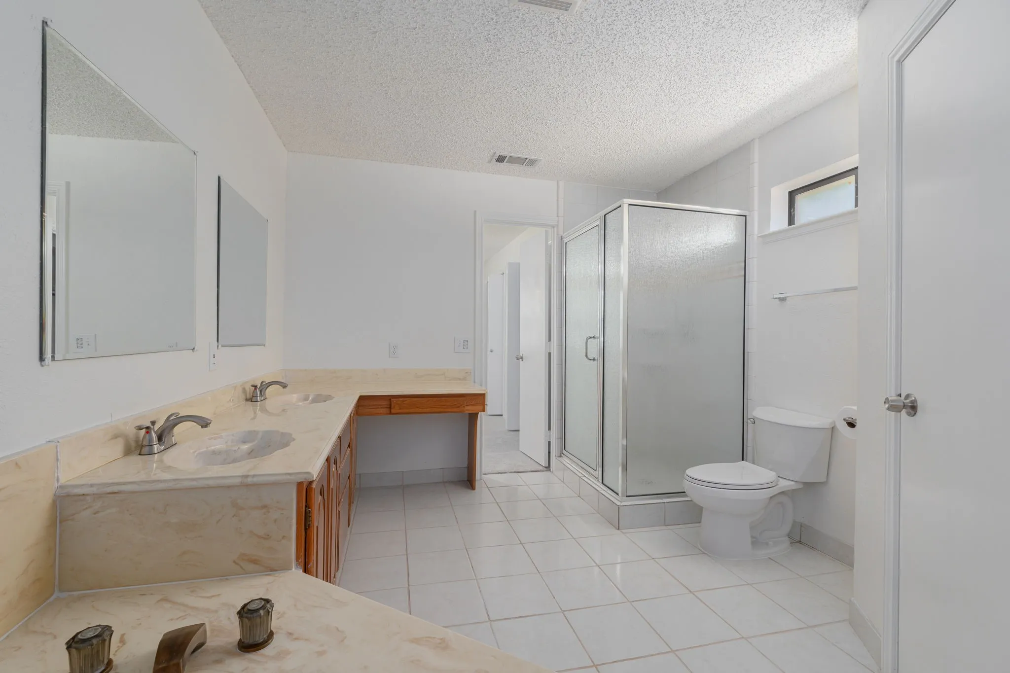 Large ensuite bath features dual sinks, oversized walk-in shower, private water closet, and a spacious layout with excellent storage and functionality.