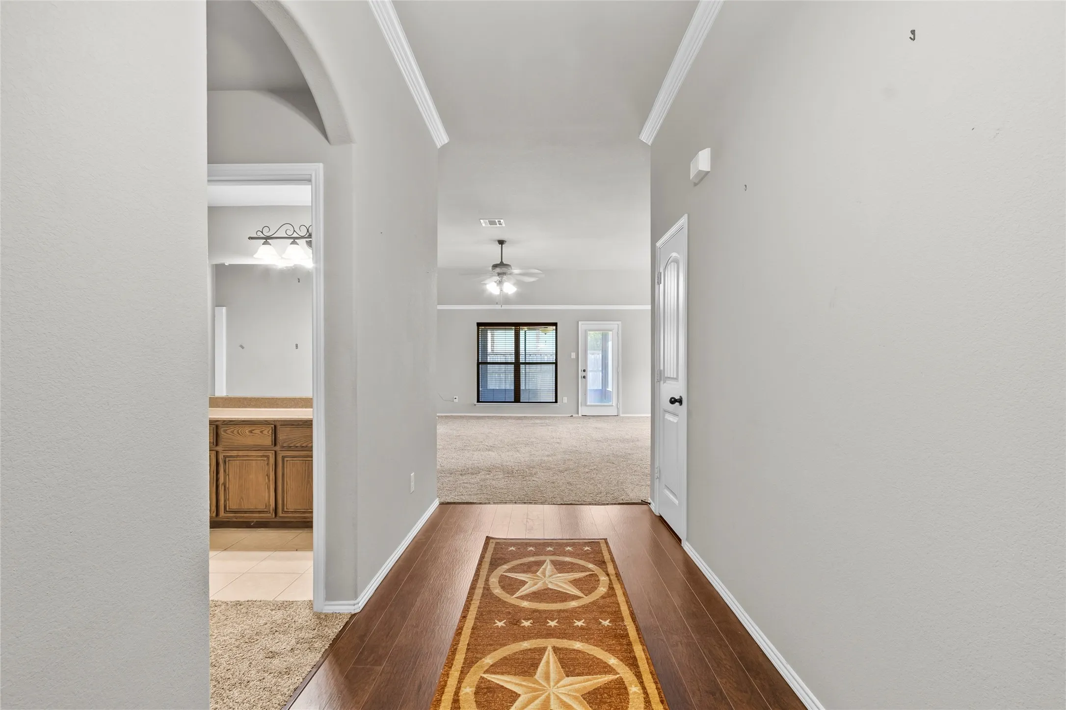 Entryway featuring wood-finish flooring, light grey walls, and white crown molding