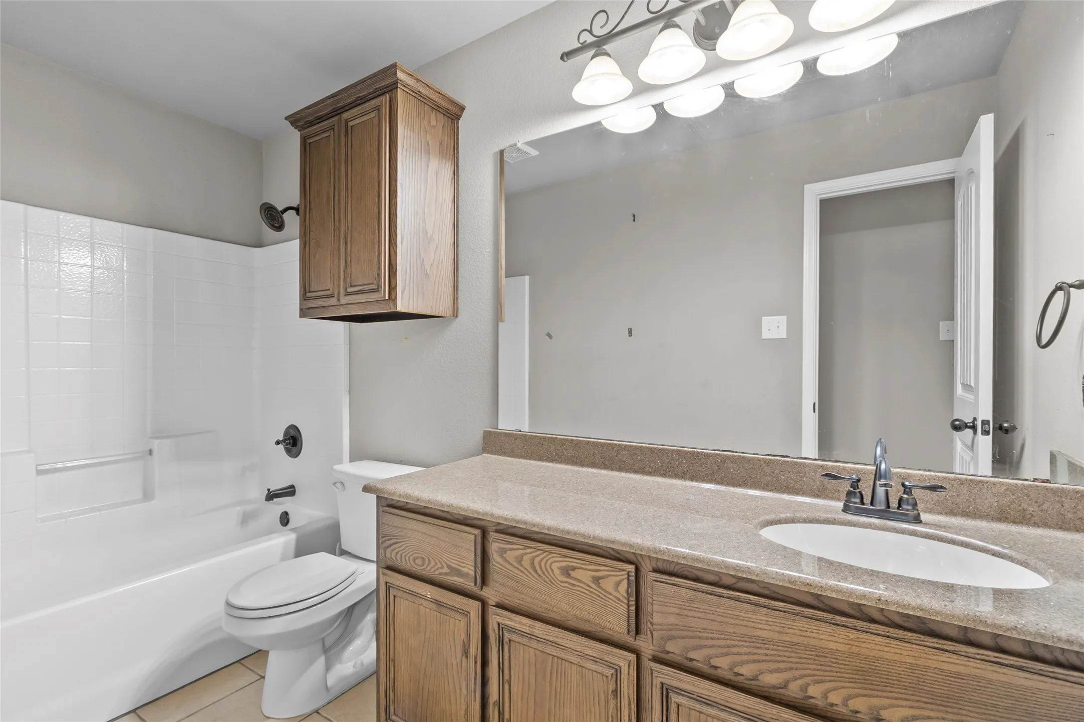 Bathroom featuring a vanity with a countertop, integrated sink, and an extensive wall-mounted mirror