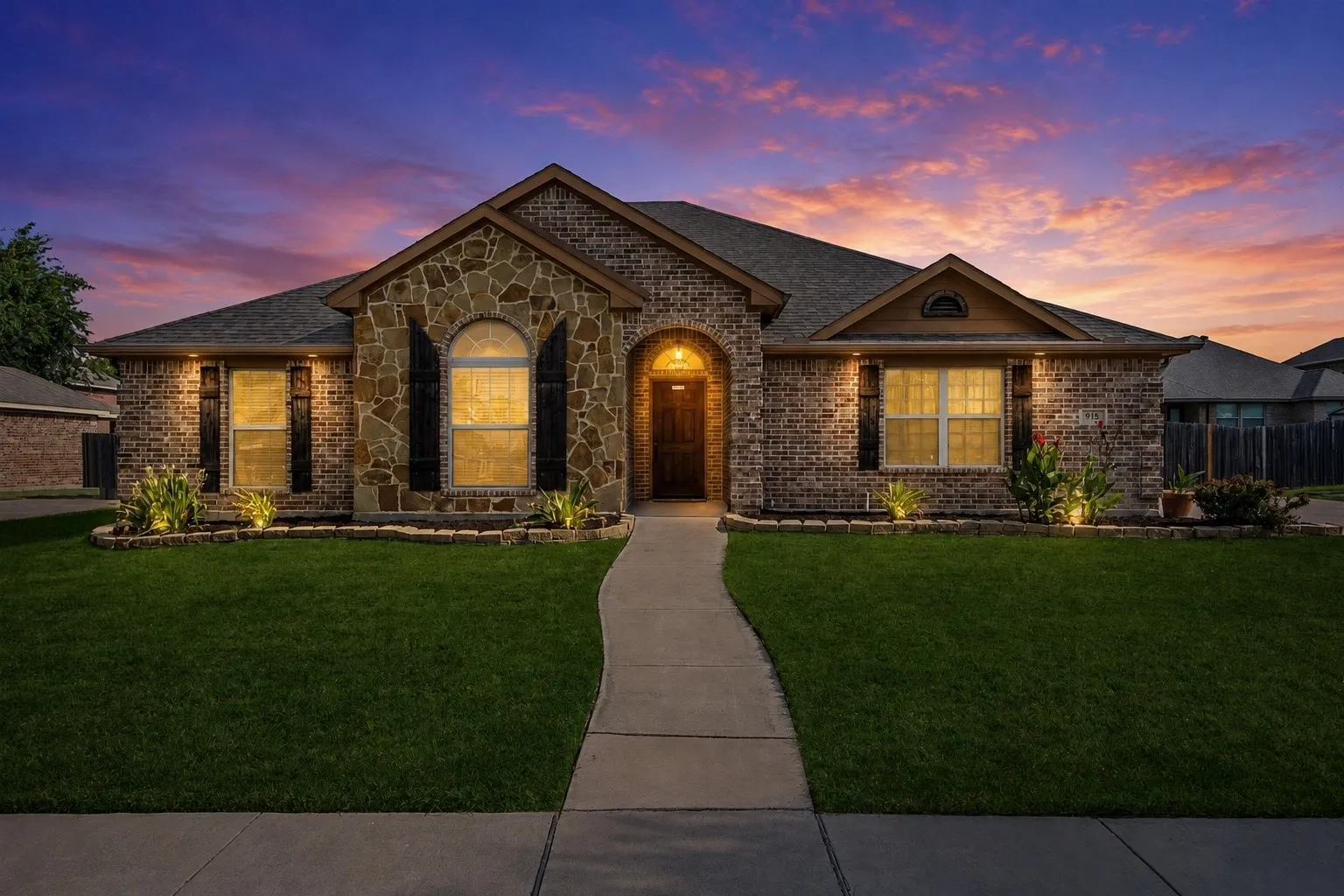 Brick and stone facade featuring arched window, arched entry, and decorative shutters